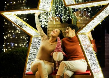Image of a two women sitting and watching the christmas lights in a giant star filled with lights